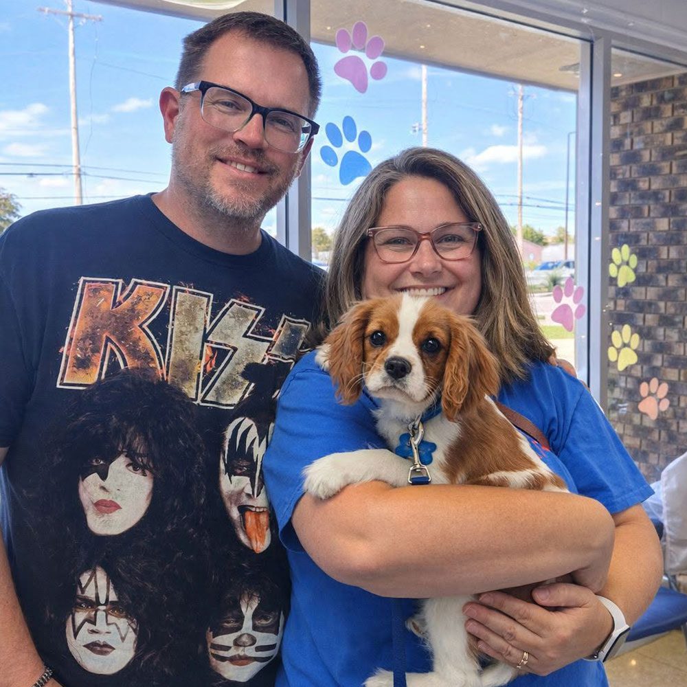 happy couple posing with dog in waiting room