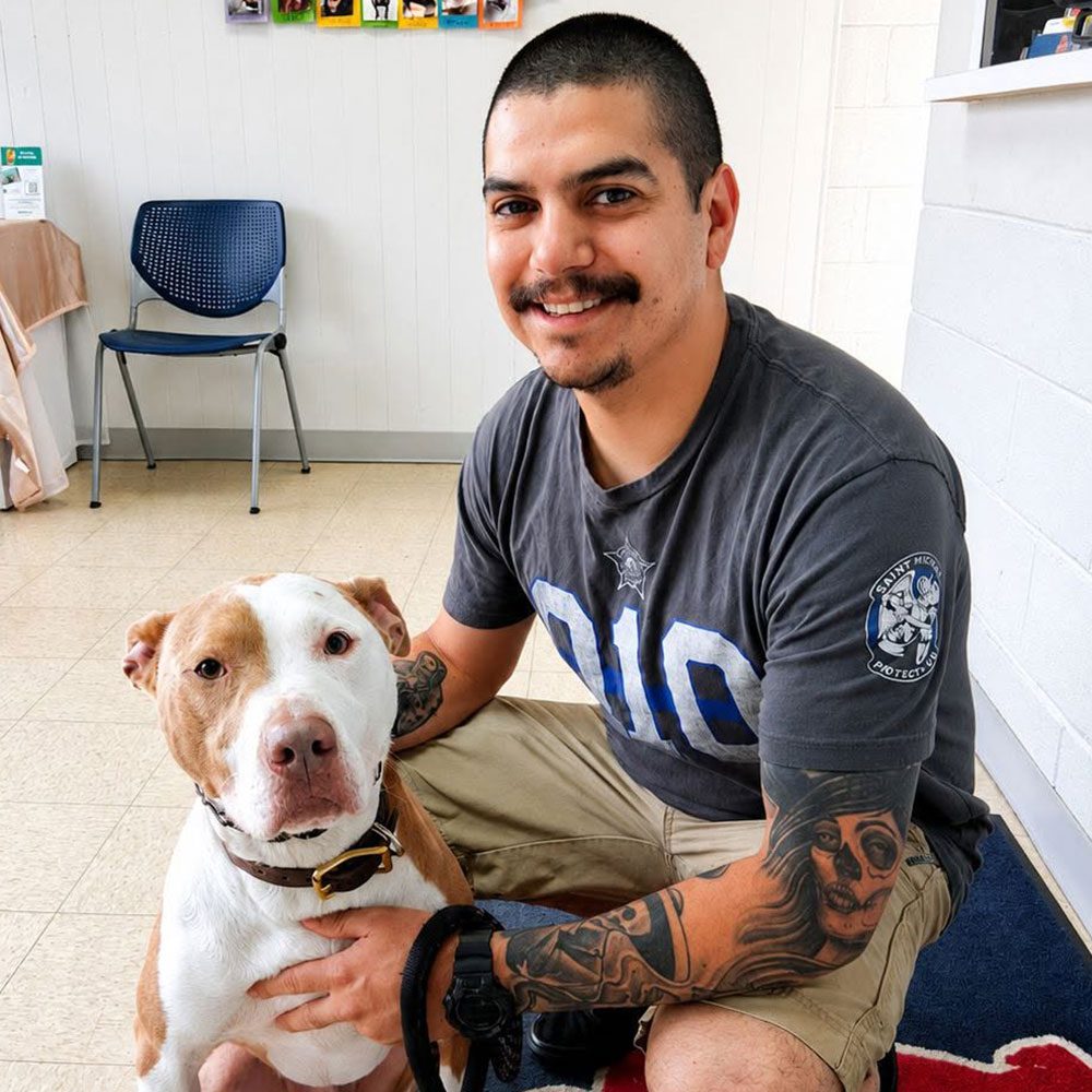 male owner posing for a picture with dog