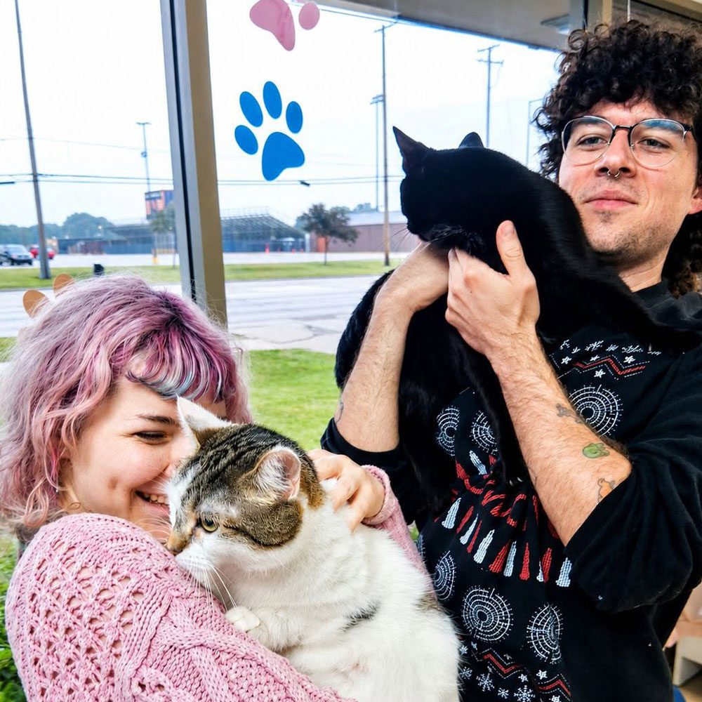 male and female holding cats in waiting room