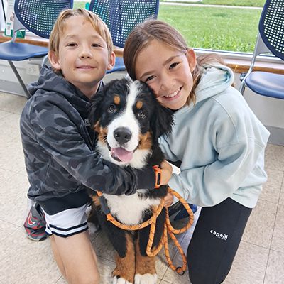 two-kids-hugging-dog-in-lobby